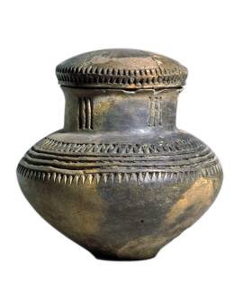 Een urn uit Limburg uit de Late Bronstijd. De urn is versierd met een patroon van uitgestoken driehoekjes en lijnen en heeft een deksel. (Foto: Rijksmuseum van Oudheden) Een urn uit Limburg uit de Late Bronstijd. De urn is versierd met een patroon van uitgestoken driehoekjes en lijnen en heeft een deksel. (Foto: Rijksmuseum van Oudheden)